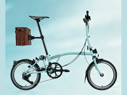 Light blue folding bike with a wicker rear basket on a Seatpost Hugger