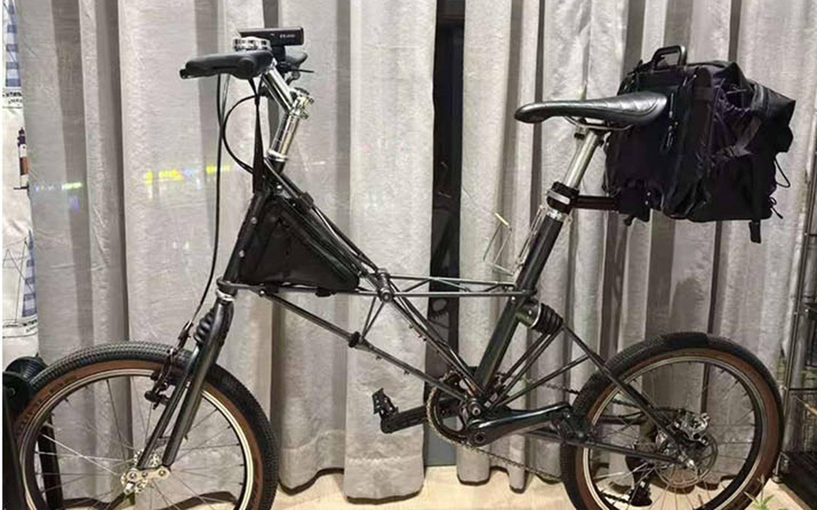 Minivelo with a black gear bag mounted behind the saddle
