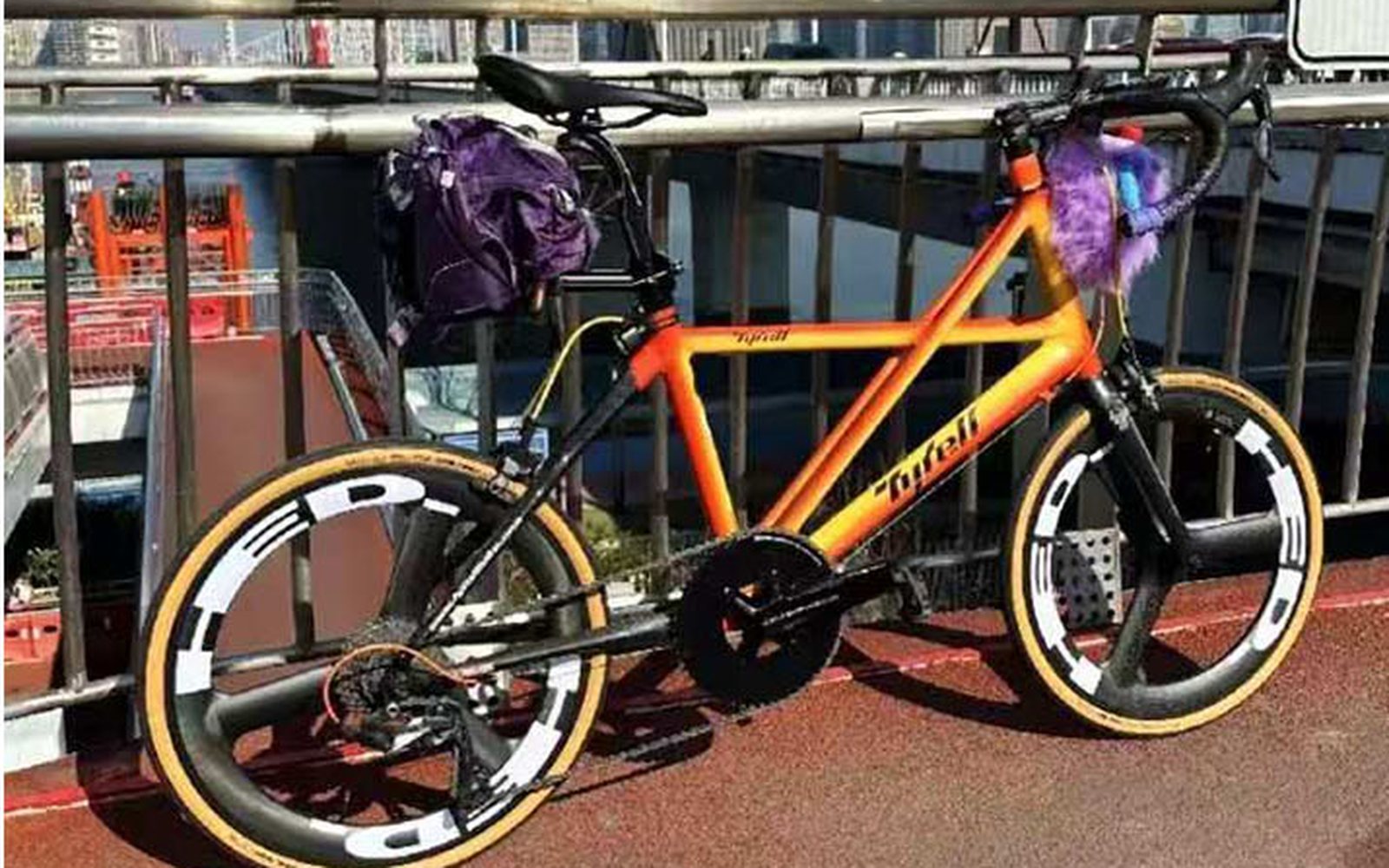 Orange-gradient small-wheel bike with a purple seatpost bag
