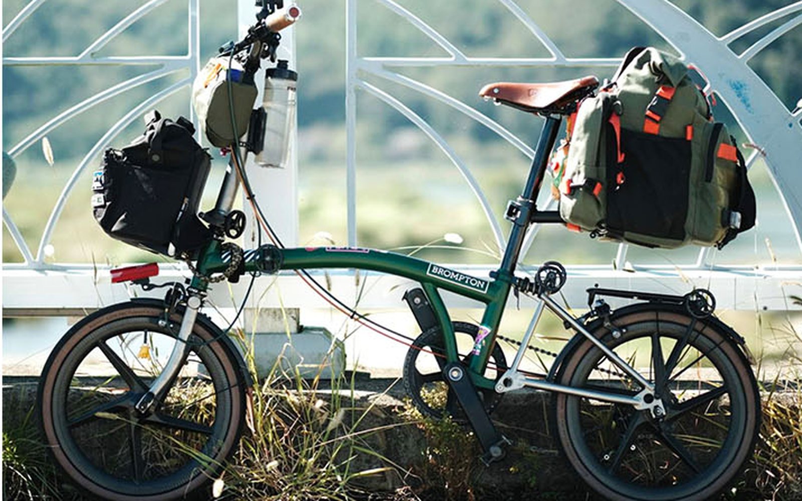Green Brompton with an olive rear bag on the seatpost