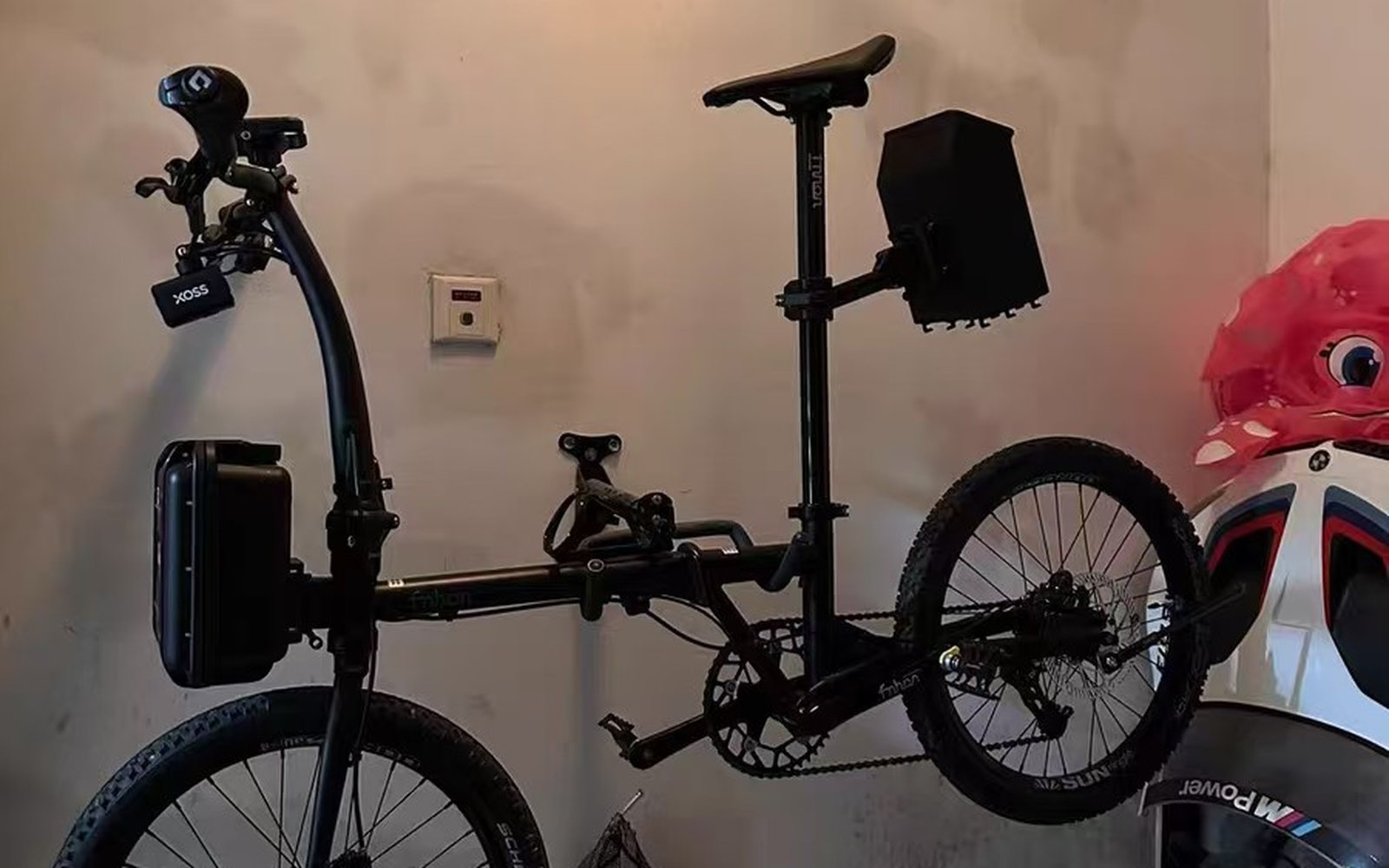 Black Fnhon folder on a wall, with a seatpost bag