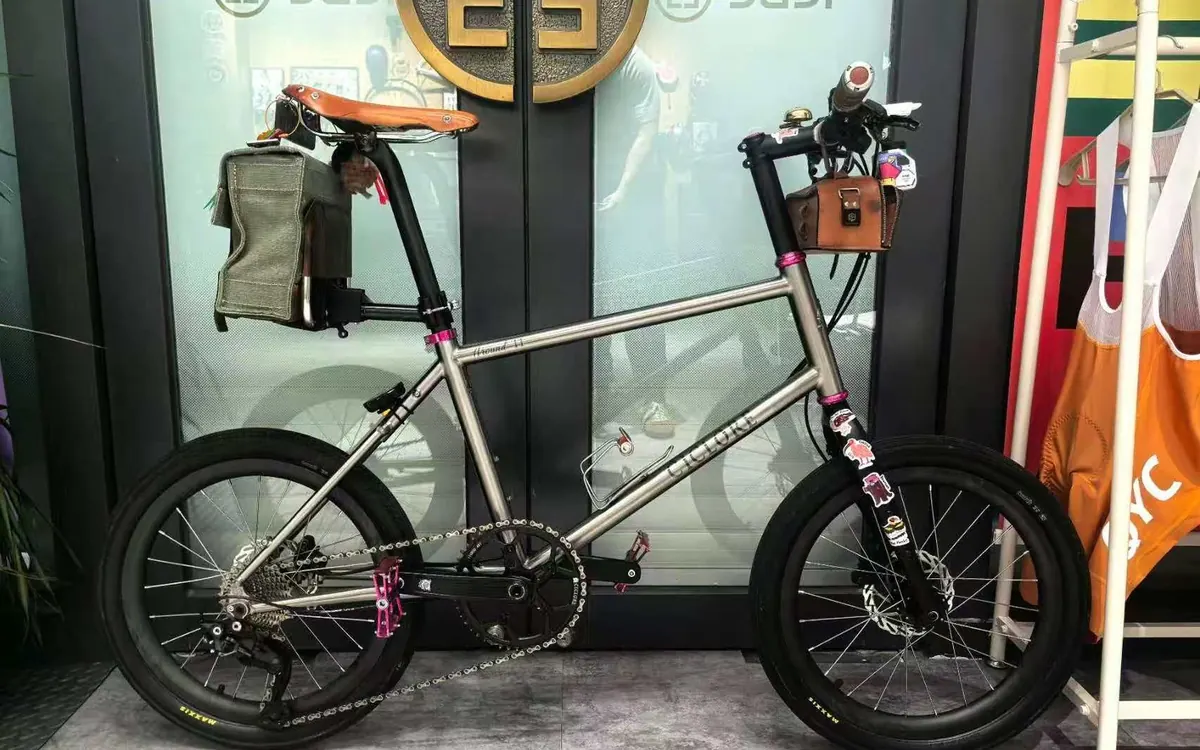 Silver minivelo with pink hardware and an olive rear bag