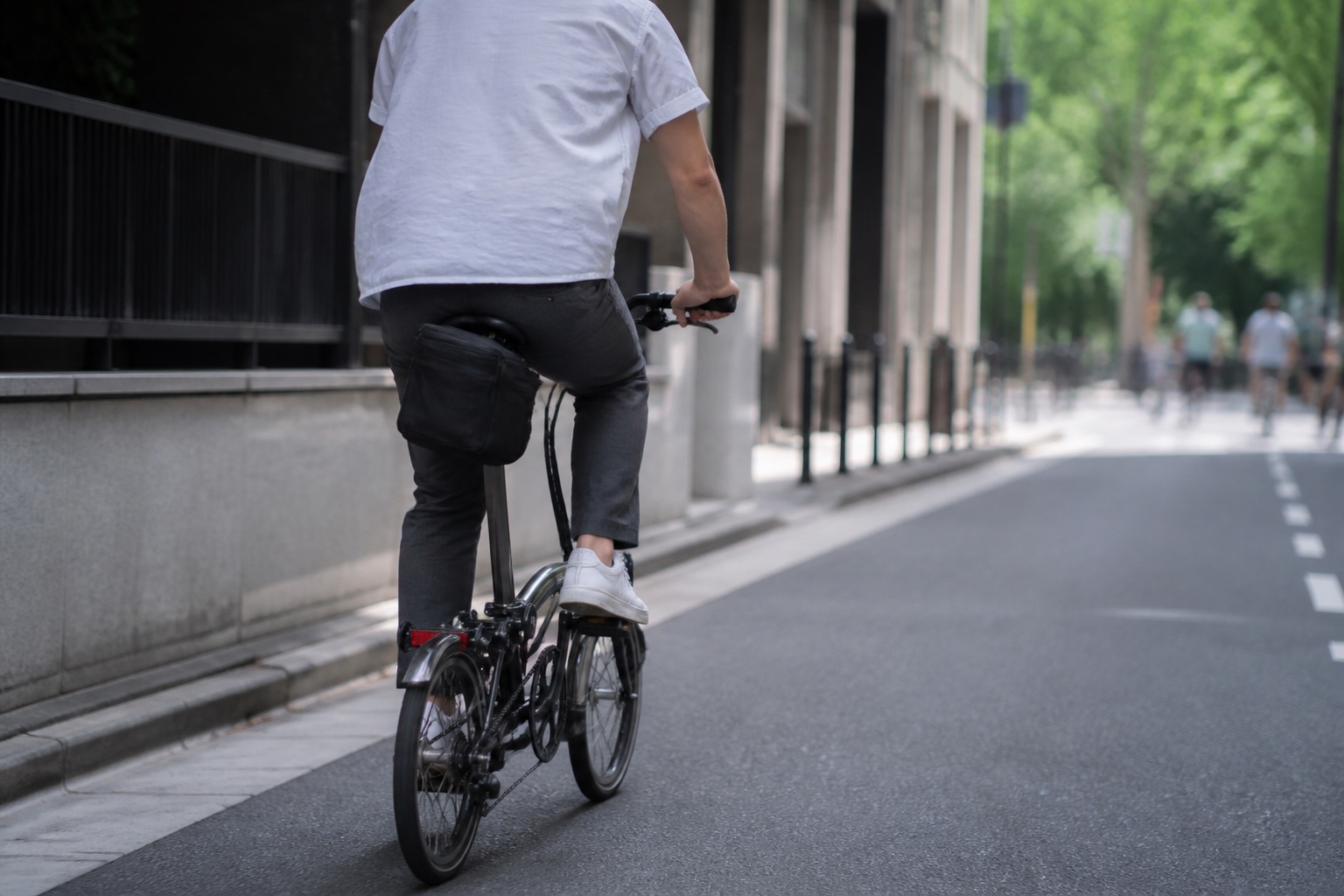 Cyclist riding with a bag mounted behind the saddle